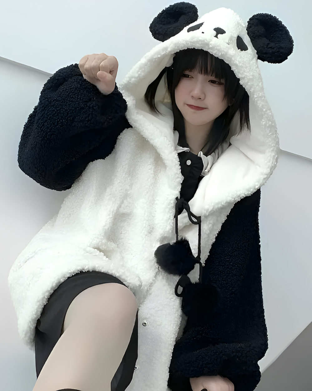 Woman wearing a Winter Hooded Coat - Panda Edition, a fluffy black and white panda fleece hoodie. The coat has panda ears on the hood.