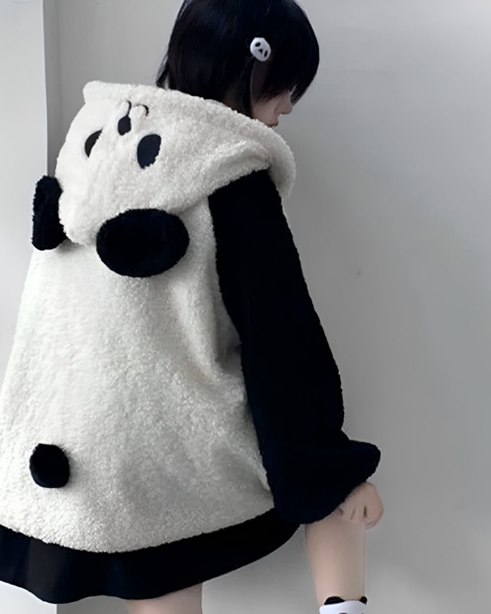 Person wearing a white and black panda fleece hoodie, a Winter Hooded Coat - Panda Edition.