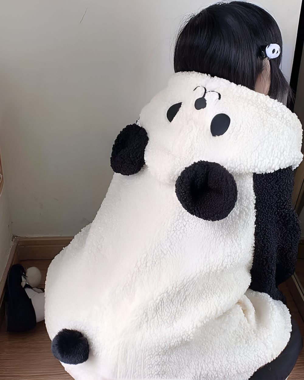 Person wearing a white and black panda fleece hoodie. The hooded jacket features a panda bear design with ears and face details.