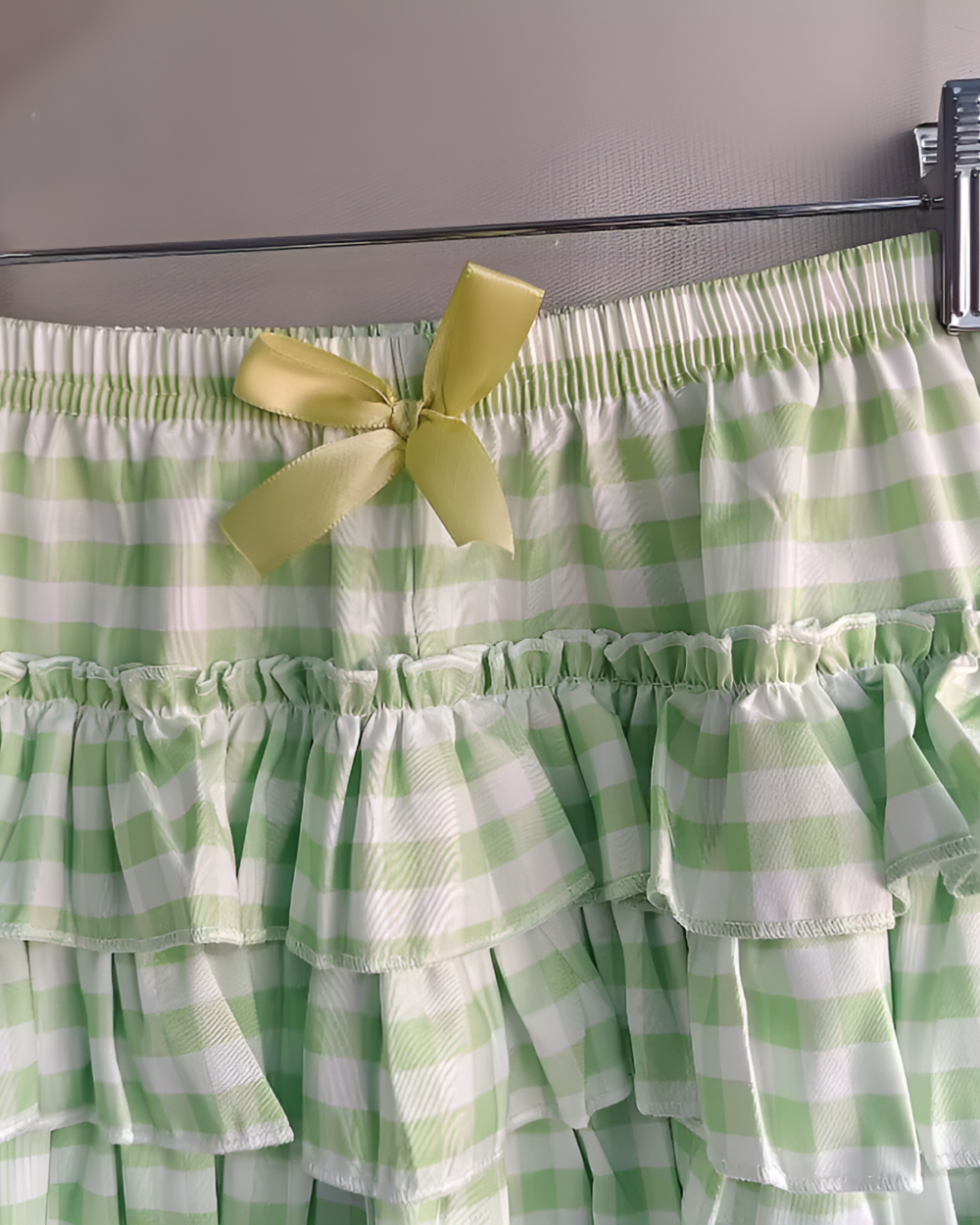 Green and white gingham Yotsuba Neko T-Shirts with a ribbon bow, displayed on a hanger.