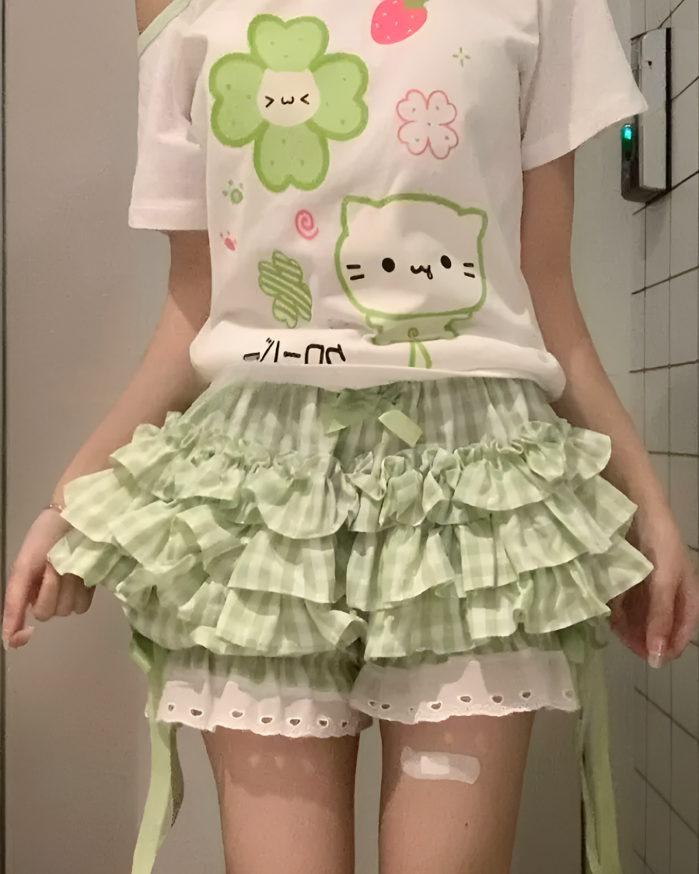 Yotsuba Neko T-Shirts featuring a cute green cat design on a pastel pink shirt and layered skirt.