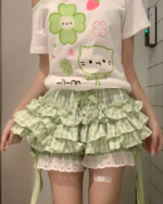 Yotsuba Neko T-Shirts featuring a cute green cat design on a pastel pink shirt and layered skirt.