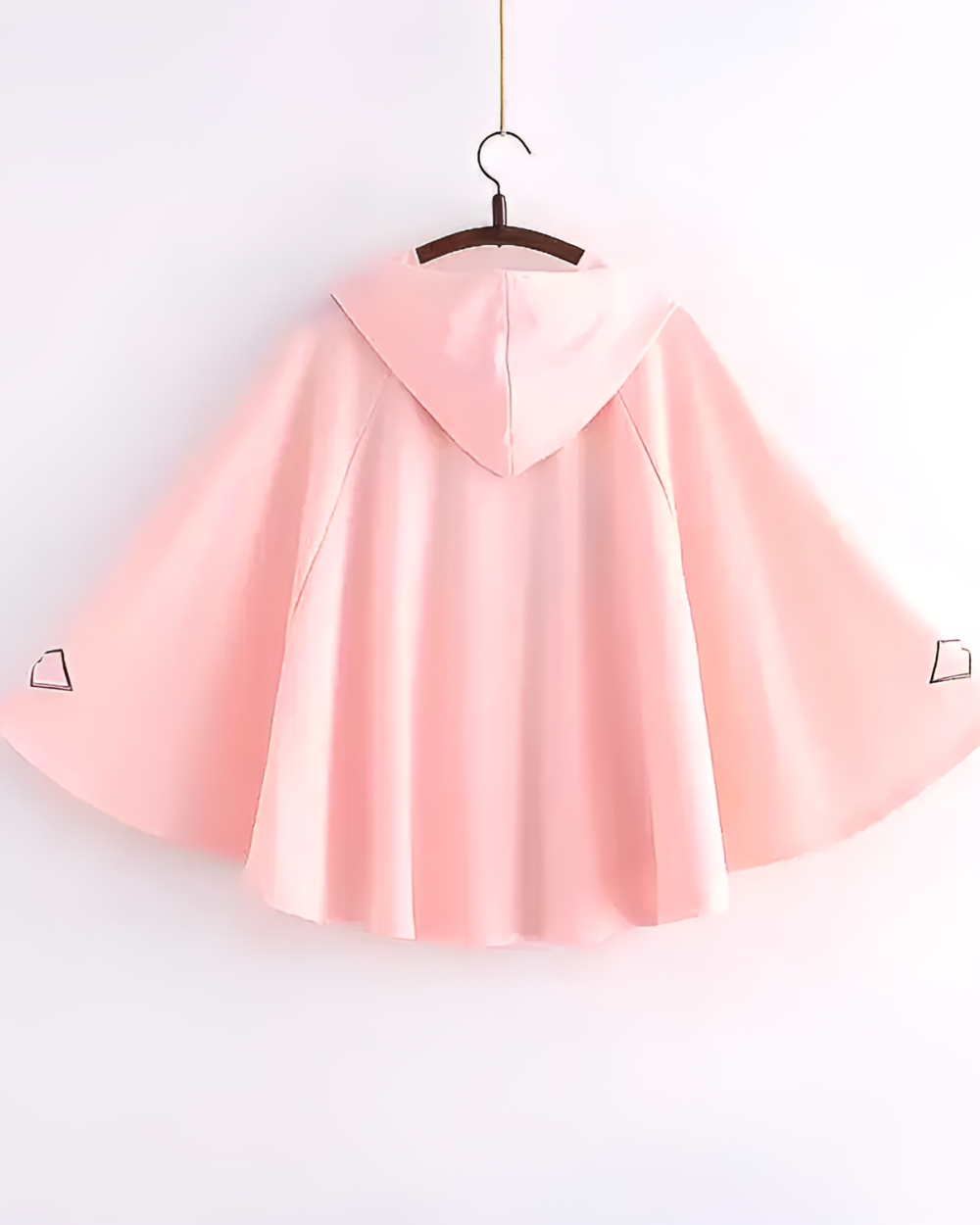 Pink hooded poncho hanging on a hanger. Zephyr Bamboo hooded poncho, lightweight and stylish.