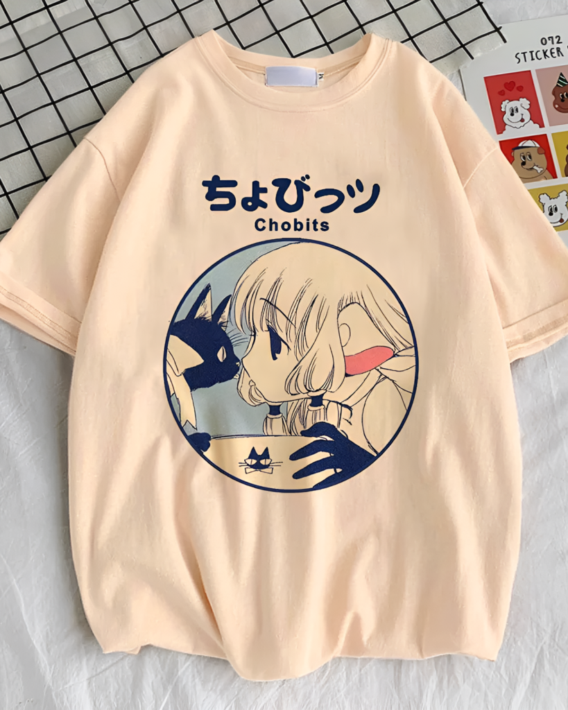 Chobits T-Shirt featuring a graphic of Chi and Hideki, with the series name in Japanese. Peach colored cotton tee.